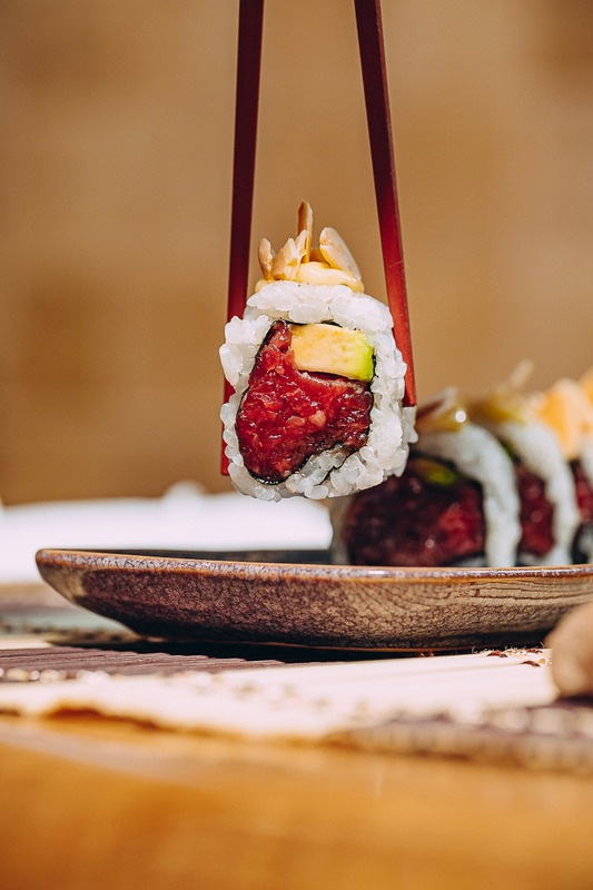 A Cantera roll lifted from the plate with chopsticks.