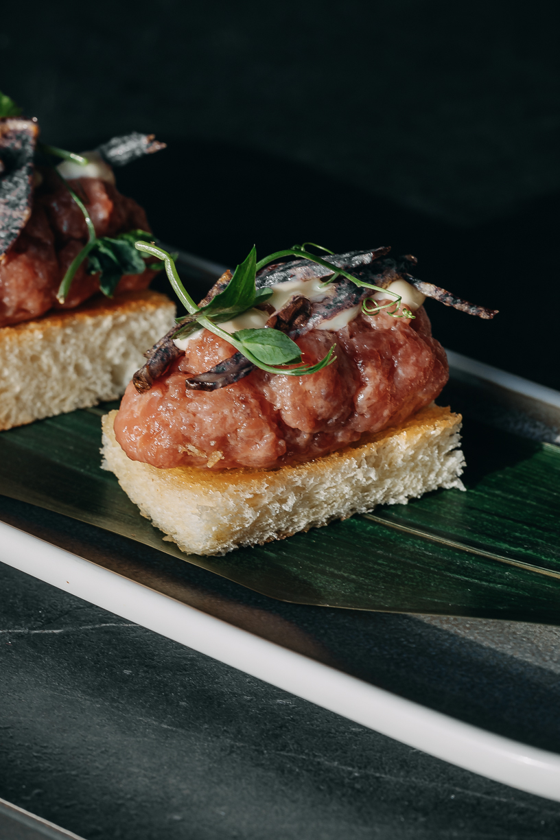 Tartare piled on crispy rice, finished with herbs and served on a banana leaf.