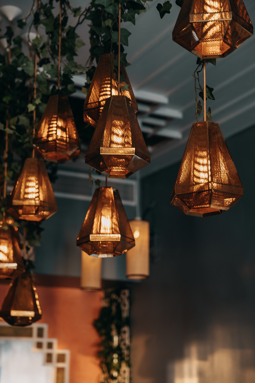 Amber pendant lamps lit above the tables as the room turns to evening.