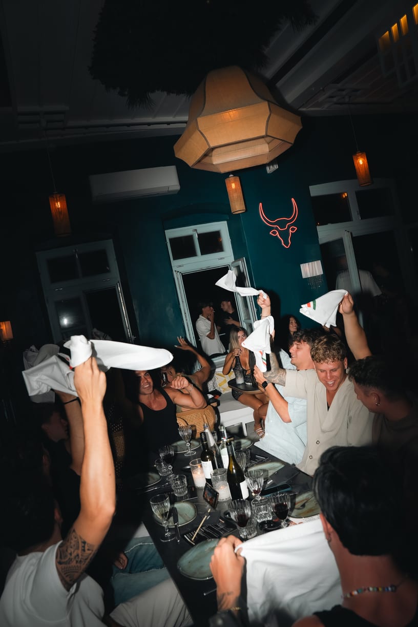 Napkins in the air under the neon bull at Mamma Mia Night.